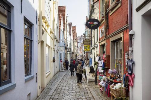 a group of people walking down a street with buildings at Holiday Inn Express Bremen Airport by IHG in Bremen