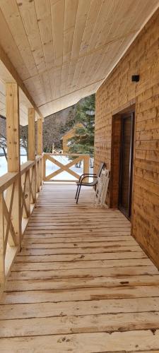 a wooden porch with a bench on a wooden deck at Leśniczówka Kalina in Wetlina