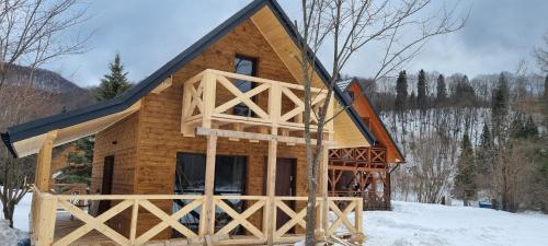 a log cabin in the snow with a large window at Leśniczówka Kalina in Wetlina