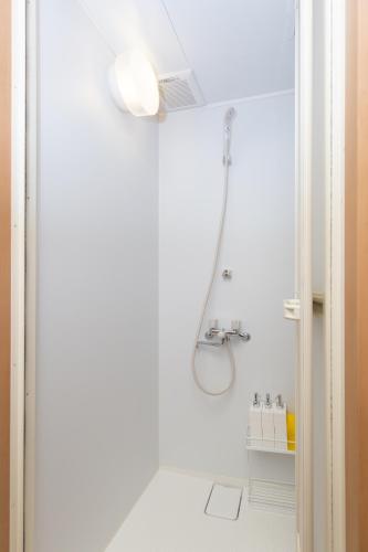 a white bathroom with a shower and a sink at 唐沢ホテル Karasawa-Hotel in Tokyo