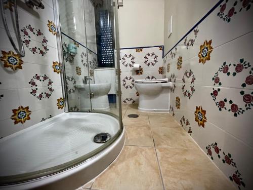 a bathroom with a toilet and a tub and a sink at Hotel Le Ceramiche in Montalto Uffugo