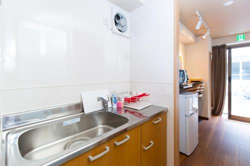 a kitchen with a stainless steel sink and a dishwasher at 唐沢ホテル Karasawa-Hotel in Tokyo
