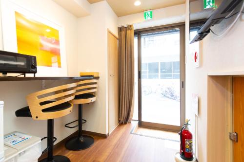 a room with a chair and a sliding glass door at 唐沢ホテル Karasawa-Hotel in Tokyo