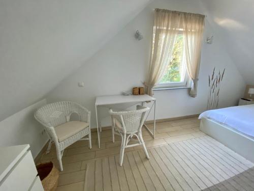 a bedroom with a bed and a desk and chairs at Ferienhäuser mit Seeblick direkt am Plauer See in Plau am See