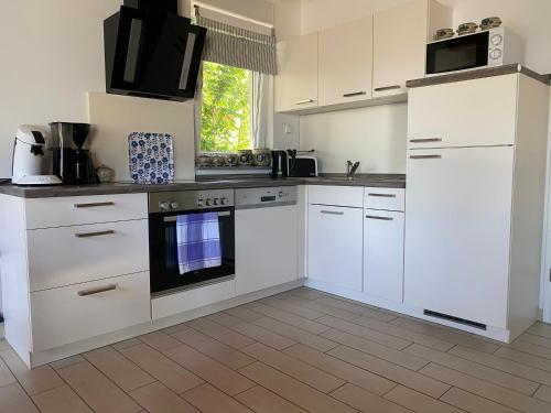 a kitchen with white cabinets and an oven at Ferienhäuser mit Seeblick direkt am Plauer See in Plau am See
