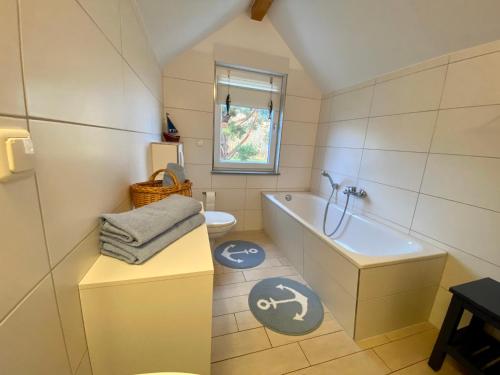 a bathroom with a tub and a toilet and a sink at Ferienhäuser mit Seeblick direkt am Plauer See in Plau am See