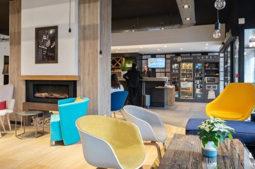 a lobby with colorful chairs and a counter at Campanile Epinal Centre - Gare in Épinal