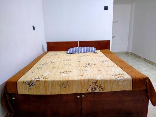 a large bed in a room with a wooden headboard at Thekkumpuram Tourist Home in Malappuram