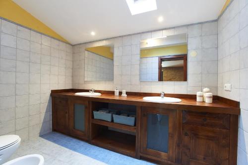 ein Badezimmer mit zwei Waschbecken und einem WC in der Unterkunft Casa Costas Ponte de Lima in Ponte de Lima