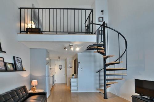 - un escalier en colimaçon dans le salon doté d'un canapé dans l'établissement O'Berge du Village C304 - Bord de l'eau, à Magog