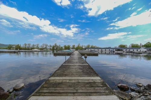 a dock on a lake with a cloudy sky at O'Berge du Village C304 - Bord de l'eau in Magog-Orford