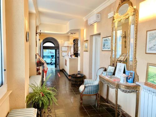 a hallway with a mirror and a table and chairs at Hotel Castello Miramare in Genova