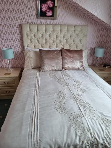 a bedroom with a white bed with two night stands at The Sands Hotel in Paignton