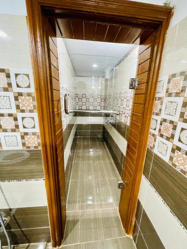 a walk in shower in a bathroom with tiles at Hotel Serena Palace in Multan
