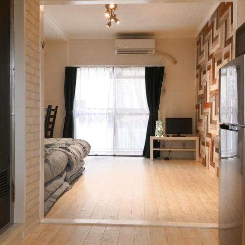 a bedroom with a bed and a window at Guest House Fukuoka W203 in Kasugabaru