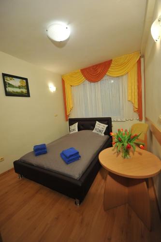 a bedroom with a bed and a table and a window at Belweder in Duszniki Zdrój