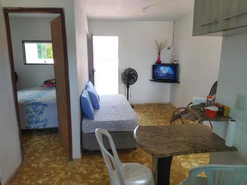 a small room with a bed and a table and chairs at Apartamento in São José da Coroa Grande