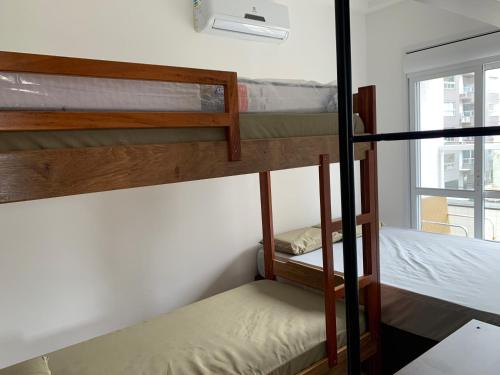 2 Etagenbetten in einem kleinen Zimmer mit Fenster in der Unterkunft SOLAMAR - PRAIA Das TONINHAS in Ubatuba