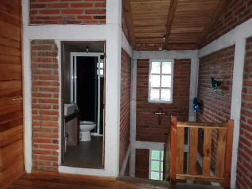 a brick bathroom with a toilet and a window at Cabañas San José de la Montaña in Mazamitla