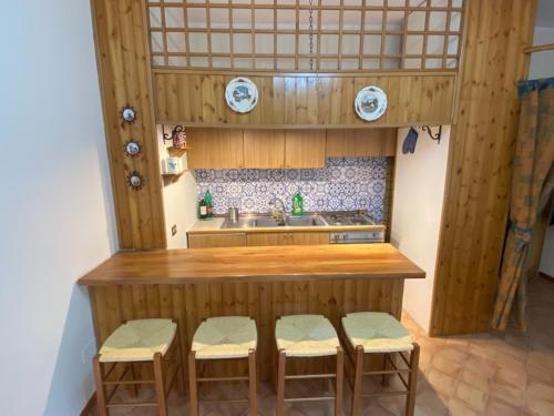 a kitchen with a counter with stools and a sink at Appartamento a Pescocostanzo in Pescocostanzo