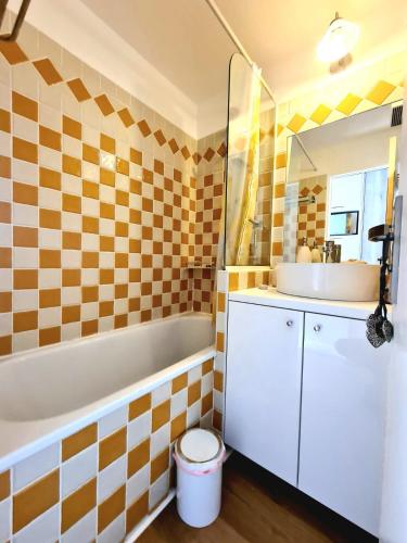 une salle de bain avec une baignoire blanche et un lavabo dans l'établissement Appartement 0321, piscine - parking - proche plages - Palmazur Vacances, à Cannes