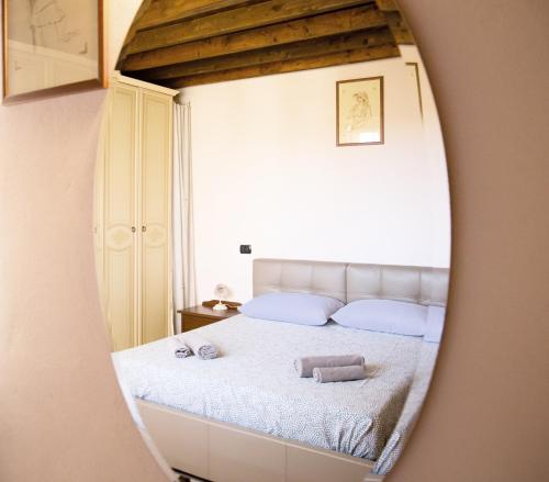 een spiegelbeeld van een bed in een slaapkamer bij FULVIA - Courtyard apartment with balcony in Arona