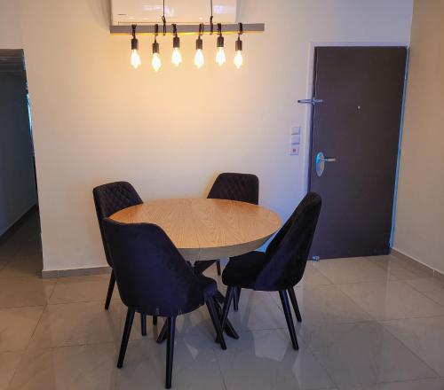 a table and chairs in a room with a door at Milano Suite in Lev Eilat in Eilat
