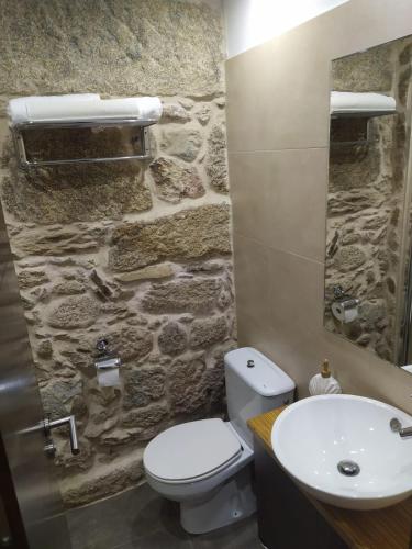 a stone bathroom with a toilet and a sink at O Recuncho do Maio in Muros