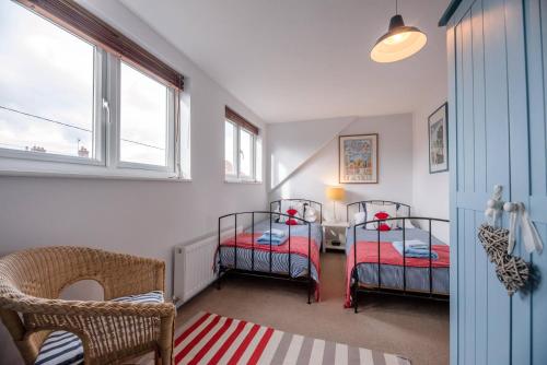 a room with two bunk beds and a window at Sandy Lane Cottage in Reydon in Southwold