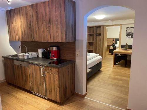 a kitchen with wooden cabinets and a bed in a room at Haus Willibald in Saalbach Hinterglemm