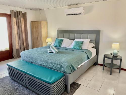Un dormitorio con una cama con un teléfono. en Entire 4BDR Vistalmar Villa with Private Pool en Oranjestad