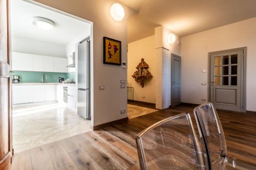 シエナにあるVilla Sienaのキッチン、白いキャビネットとウッドフロアのリビングルーム