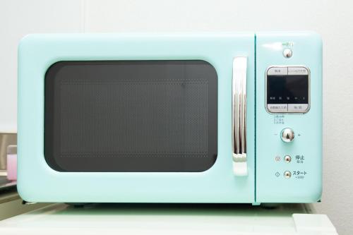 a blue microwave oven sitting on top of a counter at 唐沢ホテル Karasawa-Hotel in Tokyo