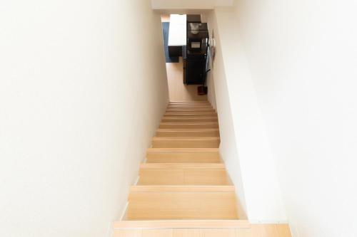 a staircase in a building with white walls and wooden floors at 唐沢ホテル Karasawa-Hotel in Tokyo