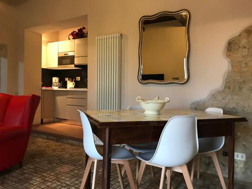 a dining room table with white chairs and a mirror at Il Fiorino di Badia in Badia A Passignano