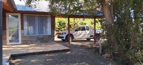 a white truck parked in front of a house at Cabañas Agua Clara in Villa Pehuenia
