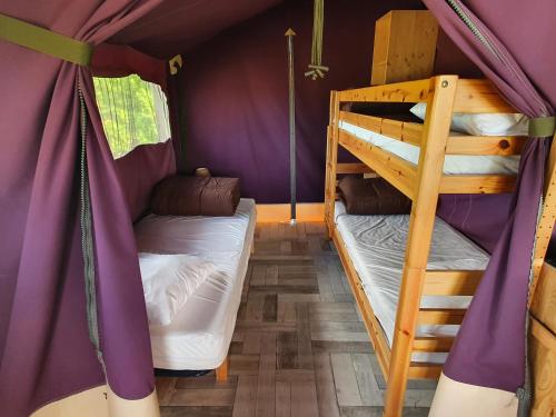 zwei Etagenbetten in einem Zimmer mit lila Wänden in der Unterkunft Camping Les Chagnelles in Le Perrier