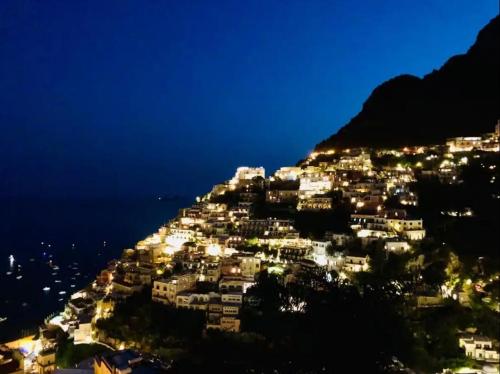 eine Stadt auf einem Berg in der Nacht in der Unterkunft House Efria in Positano