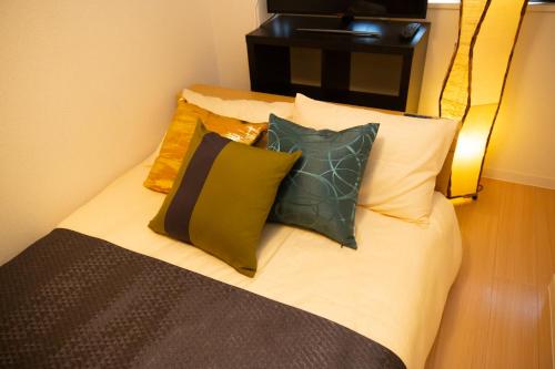 a bed with four pillows on it in a room at 唐沢ホテル Karasawa-Hotel in Tokyo