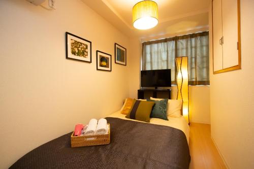 a bedroom with a bed with shoes on it at 唐沢ホテル Karasawa-Hotel in Tokyo