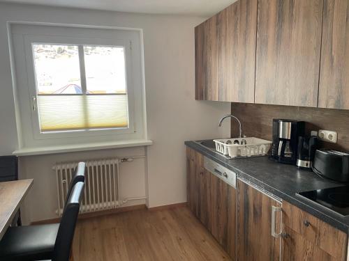 a kitchen with a counter and a sink and a window at Haus Willibald in Saalbach Hinterglemm