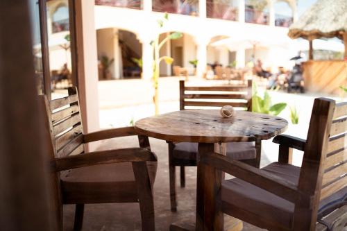 a wooden table and chairs on a patio at Paje Blu Boutique Hotel in Paje