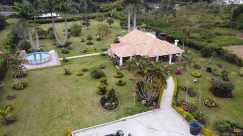an aerial view of a house with a garden at Hermosa Cabana con bonito Jardin y piscina en la Mesa de los Santos in Los Curos