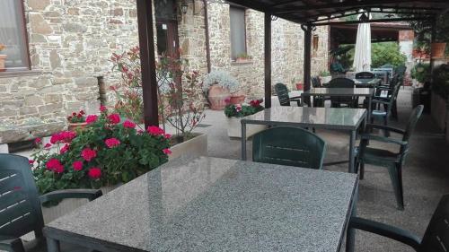 un patio al aire libre con mesas, sillas y flores en Agriturismo Santa Barbara, en Prignano Cilento