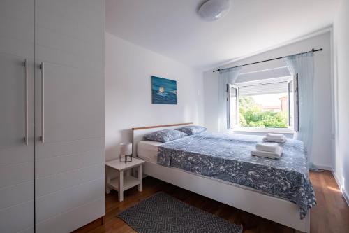 Schlafzimmer mit einem Bett und einem Fenster in der Unterkunft Apartment Vedrana 2142 in Peroj
