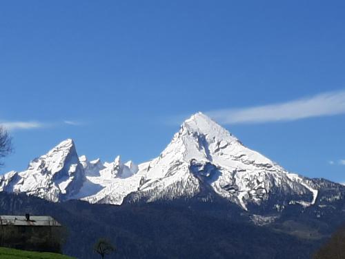 a snow covered mountain with a blue sky at Gästehaus Kurz in Berchtesgaden