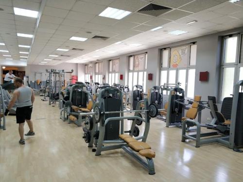 Ein Mann geht durch ein Fitnessstudio mit vielen Geräten in der Unterkunft Sweet Home in Belgrad