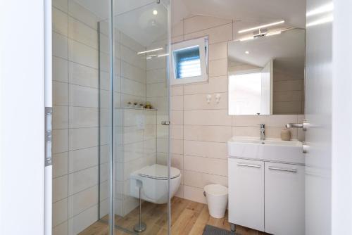 a bathroom with a shower and a toilet and a sink at Apartmani Lejla in Poljica