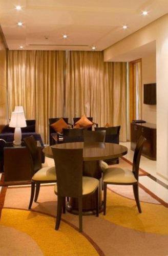 a dining room with a table and chairs and a couch at Radisson Blu Marina Hotel Connaught Place in New Delhi