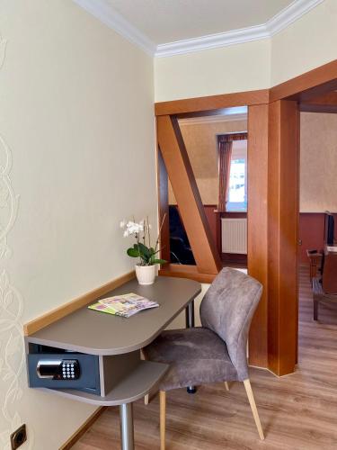 a table and a chair in a room at Haus Hohenzollern & Haus 'Ambiente in Bad Bertrich